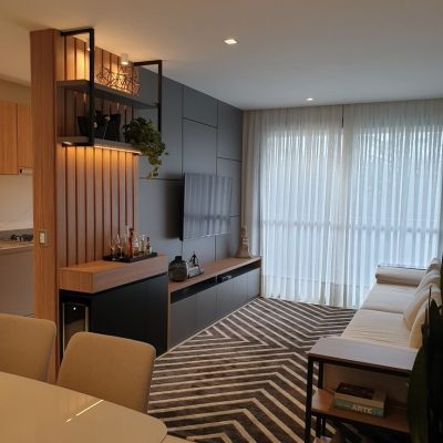 Sala de TV com aparador e nicho para aplicar uma adega e prateleiras superiores com detalhes de serralheria no acabamento preto fosco e perfil de led_